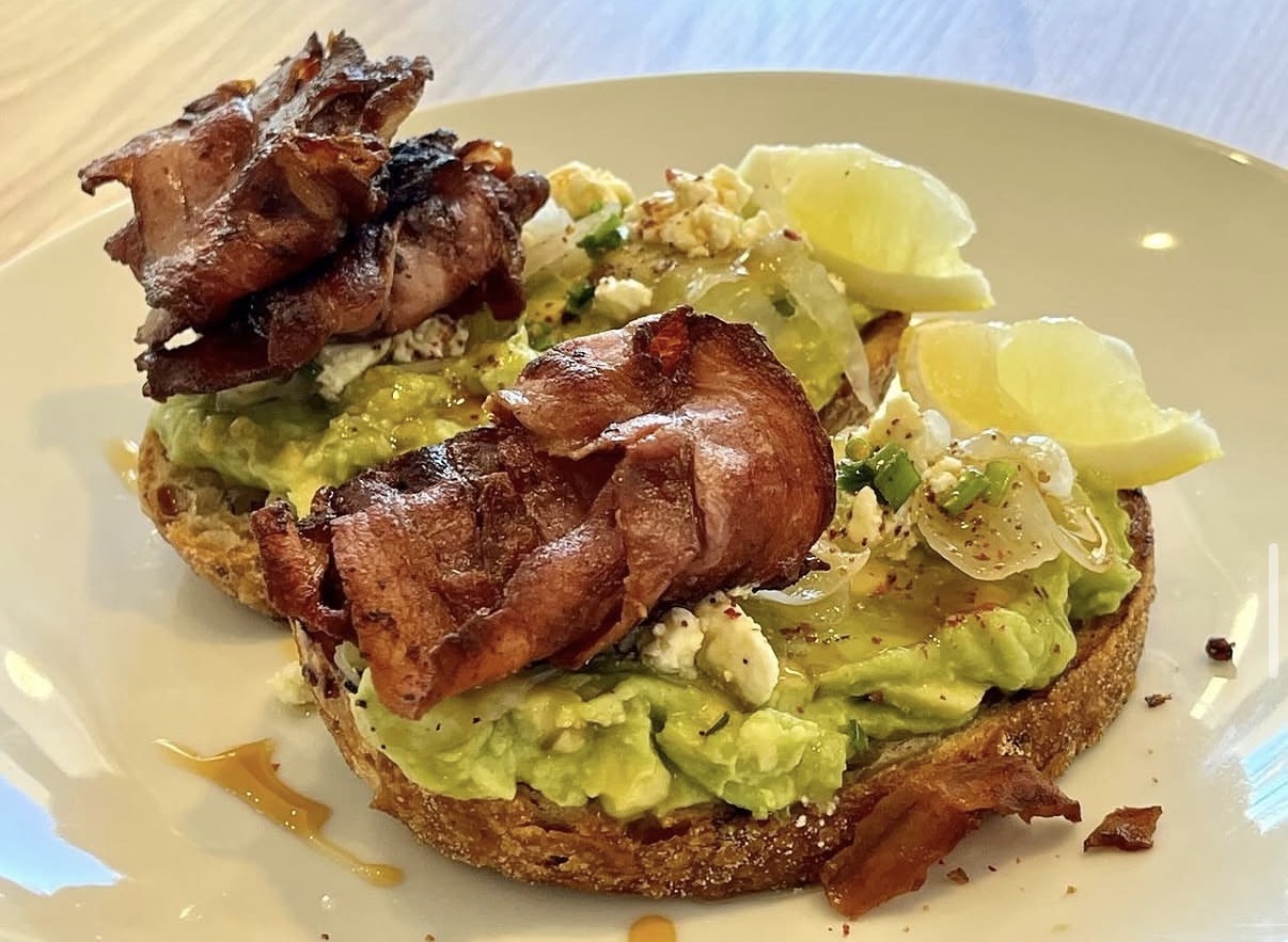 Smashed avocado on sourdough with crispy bacon